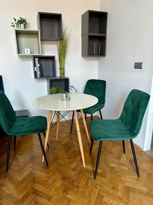 a table and four green chairs in a room at Modern studio in the heart of the city in Maribor