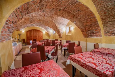 a restaurant with red tables and chairs and a brick wall at Bed & Breakfast Šilak in Ptuj