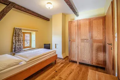 a bedroom with a bed and a wooden cabinet at Bed & Breakfast Šilak in Ptuj