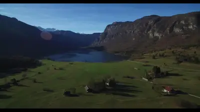 an aerial view of a golf course with a lake and mountains at Apartment Jezero Lake Bohinj in Bohinj