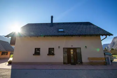 a small white building with a black roof at Apartment Jezero Lake Bohinj in Bohinj
