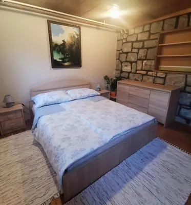 a bedroom with a bed and a stone wall at Apartment Sopar in Škofja Loka