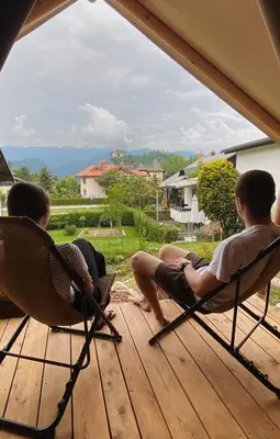 two people sitting in lawn chairs on a deck at Quercus Apartments Bled in Bled