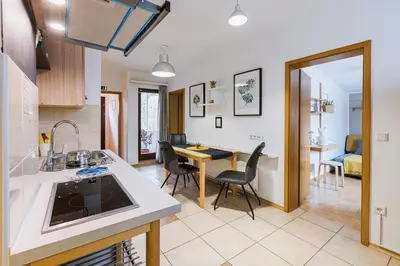 a kitchen and living room with a table and chairs at Quercus Apartments Bled in Bled