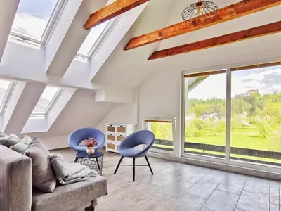 a living room with blue chairs and large windows at Deerwood-Large Villa relax with castle view in Bled