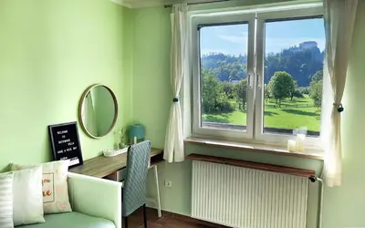 a room with a window and a chair and a mirror at Deerwood-Large Villa relax with castle view in Bled