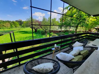 a balcony with chairs and a couch and a view of a field at Deerwood-Large Villa relax with castle view in Bled