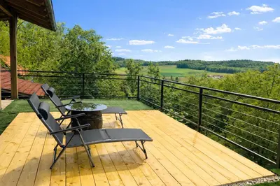 a patio with two chairs and a table on a deck at Papa Franks House in Ptuj