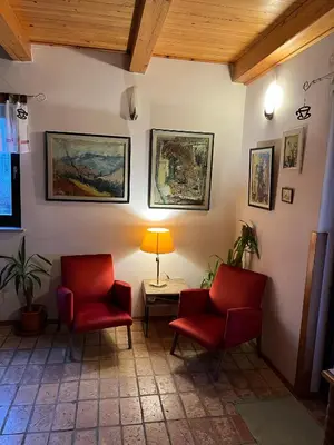 a waiting room with two red chairs and a table at Papa Franks House in Ptuj