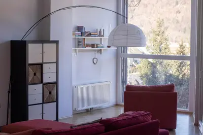 a living room with a red couch and a large window at Bright loft near Bohinj lake in Bohinj