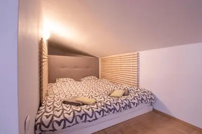 a bed with two pillows in a small room at Bright loft near Bohinj lake in Bohinj