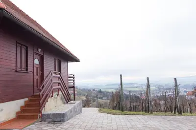 a house with a staircase next to a building at Brunarica Čontoš in Lendava