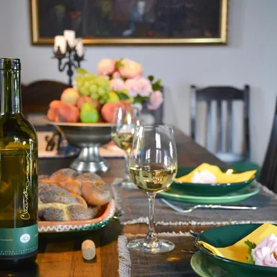 a wooden table with glasses of wine and food on it at Vinum Vidae in Lendava