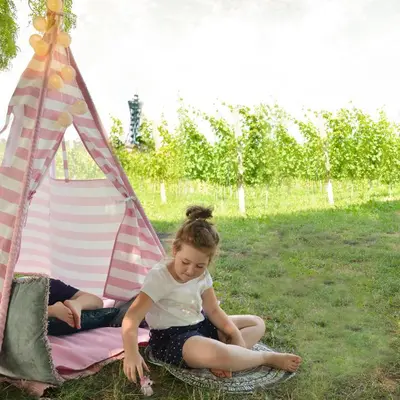 a little girl sitting in front of a tent at Vinum Vidae in Lendava