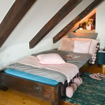 a bedroom with a bed with pillows on it at Vinum Vidae in Lendava