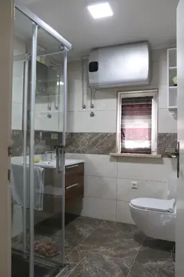 a bathroom with a shower and a sink and a toilet at Vila Tamaškut in Lendava