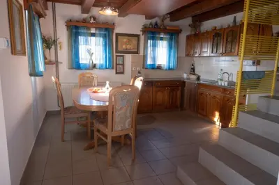 a kitchen with a table and chairs and a sink at Zidanica Balantič in Dobrovnik