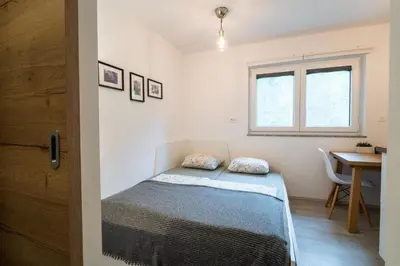 a bedroom with a bed and a desk and a window at Apartment Loyd, Kranjska Gora - studio in Kranjska Gora