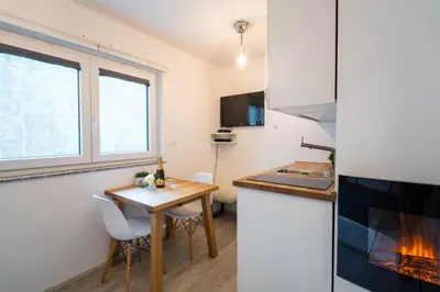 a small kitchen with a table and chairs and a stove at Apartment Loyd, Kranjska Gora - studio in Kranjska Gora