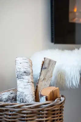 a basket filled with logs and wooden sticks at Apartment Loyd, Kranjska Gora - studio in Kranjska Gora