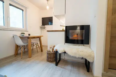 a living room with a fireplace and a table at Apartment Loyd, Kranjska Gora - studio in Kranjska Gora