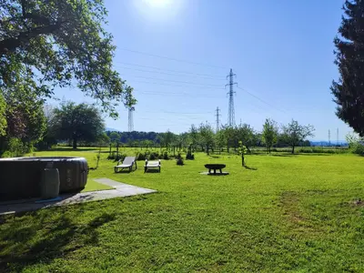 a park with benches and picnic tables in the grass at Silent Orchard in Naklo