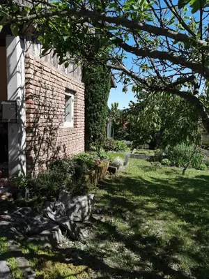 a brick building with a window in a yard at Hiška pod Krasom in Renče