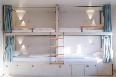 a room with three bunk beds with a ladder at Hostel Kobarid in Kobarid