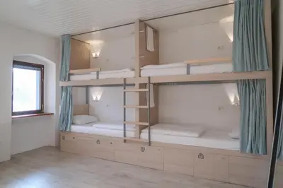 a room with four bunk beds with a window at Hostel Kobarid in Kobarid