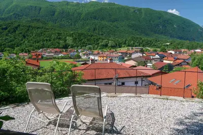 two chairs sitting on top of a hill overlooking a town at Hostel Kobarid in Kobarid