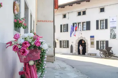 a basket of flowers hanging on the side of a building at Hostel Kobarid in Kobarid