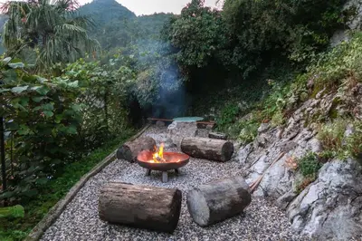 a fire pit with logs on a rocky ground at Hostel Kobarid in Kobarid