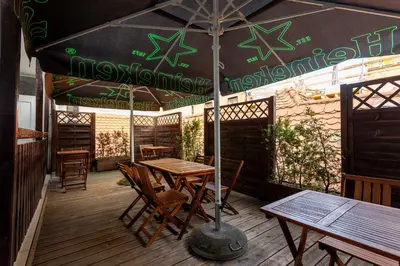 a table and chairs under an umbrella on a deck at Patrick's Pub in Maribor
