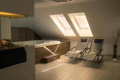 a bathroom with two chairs and a bath tub at Hotel Aqua Roma in Rimske Toplice
