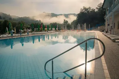 a swimming pool with a stairway leading to the water at Hotel Aqua Roma in Rimske Toplice