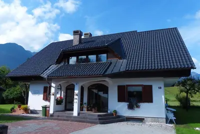 a white house with a black roof at Guest House Alenka in Bohinj