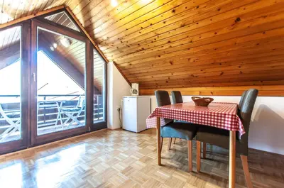 a dining room with a table and chairs and a refrigerator at Guest House Alenka in Bohinj