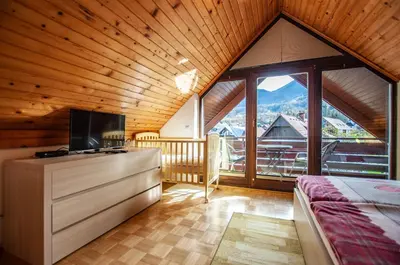 a bedroom with a bed and a large window at Guest House Alenka in Bohinj