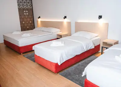 three beds in a room with white and red at Bed and Breakfast Portal in Ljubljana