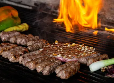 a bunch of sausages and meat on a grill at Bed and Breakfast Portal in Ljubljana