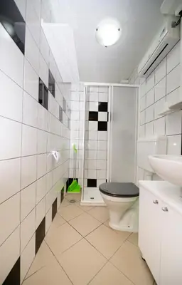 a white bathroom with a toilet and a sink at Apartma Vidmar Otlica in Ajdovščina