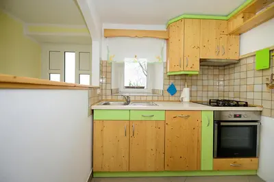 a kitchen with wooden cabinets and a sink at Apartma Vidmar Otlica in Ajdovščina