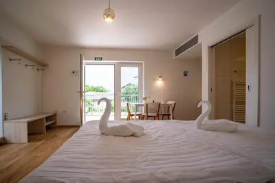 two swans sitting on a bed in a bedroom at Accommodation Baron in Ljubljana