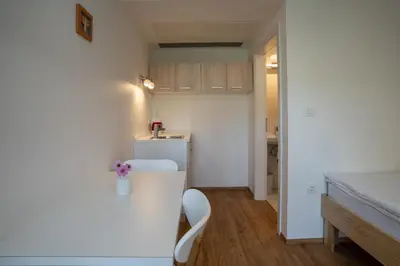 a small kitchen with a white counter and a white chair at Accommodation Baron in Ljubljana