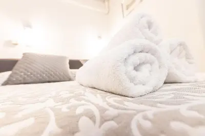 a white bed with towels on top of it at Apartments Vila Golf - Flucher Turizem in Rogaška Slatina