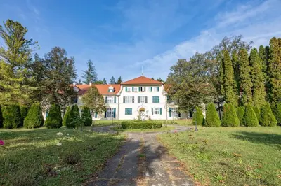 a large white house with a pathway in a yard at Apartments Vila Golf - Flucher Turizem in Rogaška Slatina