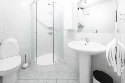 a white bathroom with a shower and a sink at Apartments Vila Golf - Flucher Turizem in Rogaška Slatina