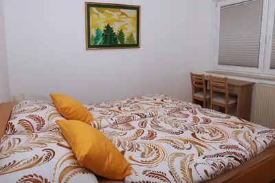 a bed in a room with a picture on the wall at Apartma Dolinar in Gorenja Vas