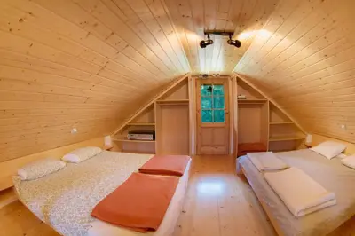a large room with two beds in a wooden house at Little dream house in a perfect spot in Zalog