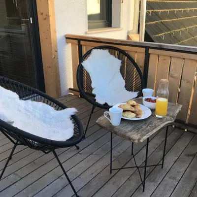 two chairs and a table with a plate of food and orange juice at LAKE HOUSE BOHINJ in Bohinj